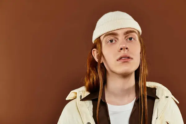 Un adolescent élégant aux cheveux roux saisissants pose en toute confiance dans un environnement studio créatif. — Photo de stock