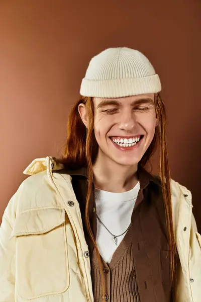 A teenage boy with bright red hair is smiling while dressed in trendy clothing, set in a studio. — Stock Photo