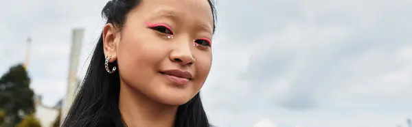 A trendy young Asian student confidently showcases her unique style near the university. — Stock Photo