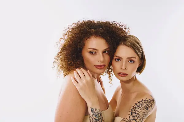 A stunning lgbt couple showcases their love and diversity with natural makeup in a serene studio environment. — Stock Photo