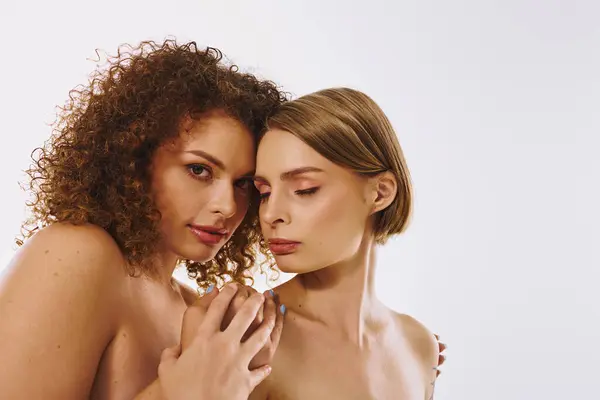 Two women celebrate their love and diversity, showcasing natural beauty in a serene studio atmosphere. — Stock Photo