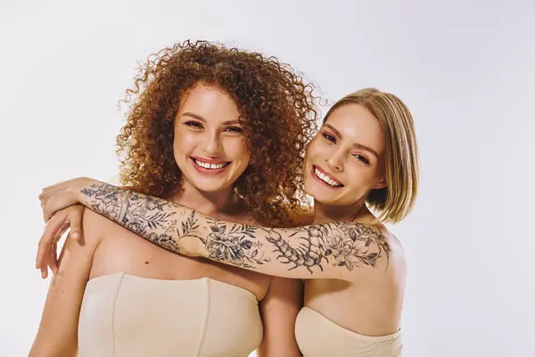 A beautiful lgbt couple with natural makeup embraces, smiling brightly and showcasing their love. — Stock Photo