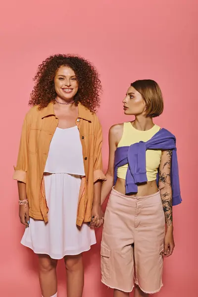 Живая пара неуверенно держится за руки, демонстрируя свою любовь и радость на игривом розовом фоне.. — стоковое фото