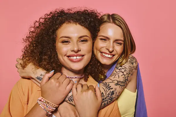A joyful couple embraces each other lovingly against a vibrant pink backdrop, showcasing beauty. — Stock Photo