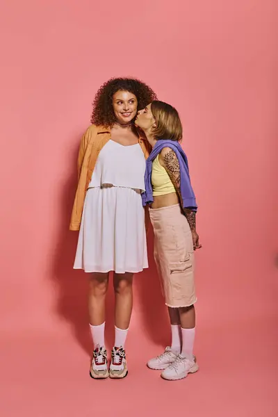 Two lgbt women share a loving moment in a vibrant studio, radiating joy against a pink backdrop. — Stock Photo