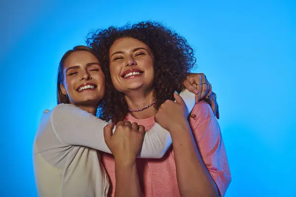 A joyful lgbt couple embraces in a studio, showcasing love and diversity against a vibrant pink backdrop. — Stock Photo