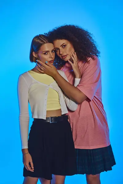 Two joyful women showcase their love and connection against a vibrant pink backdrop, embracing diversity. — Stock Photo