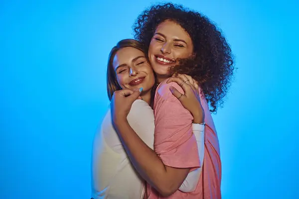 Two happy women share a loving moment, showcasing their connection and diversity with bright smiles. — Stock Photo