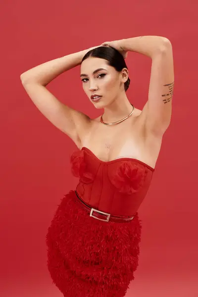 Una mujer hermosa muestra su sentido de la moda en un conjunto rojo llamativo, exudando confianza. - foto de stock