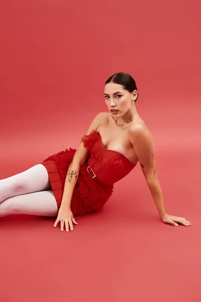 A fashionable woman lies gracefully on a pink surface, exuding confidence and style. — Stock Photo