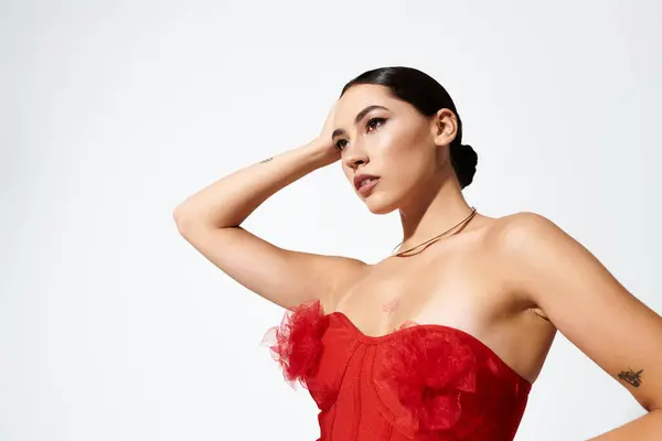 The young beautiful woman showcases confidence while elegantly posing in her chic red dress. — Stock Photo