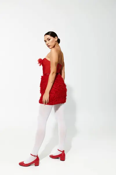A stylish young woman showcases a playful red dress and matching shoes with elegance and flair — Stock Photo