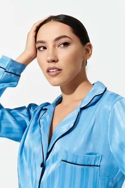 A beautiful woman showcases her charming style and confidence while dressed in blue sleepwear. — Stock Photo