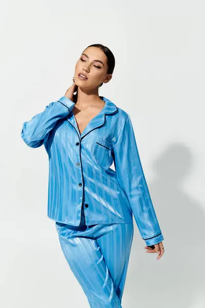 Una hermosa joven modelo vibrante pijama azul con un comportamiento relajado y seguro. - foto de stock