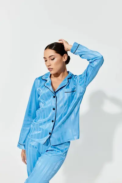 The young woman showcases a vibrant blue pajama set, striking a fashionable pose. — Stock Photo