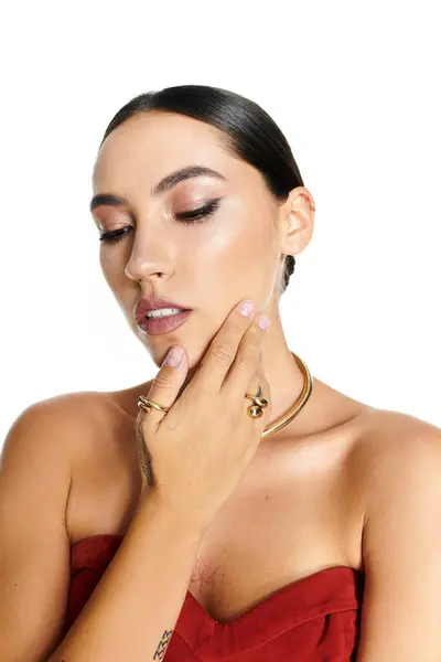A young beautiful woman touches her face, highlighting her radiant skin and jewelry. — Stock Photo