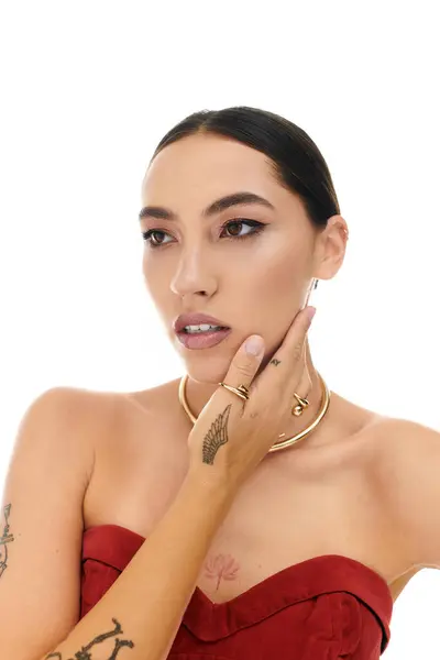 A young woman gracefully poses, emphasizing her jewelry and striking features in a chic style. — Stock Photo