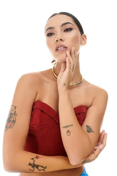 La joven posa elegantemente, destacando su sentido de la moda y sus intrincados tatuajes. - foto de stock