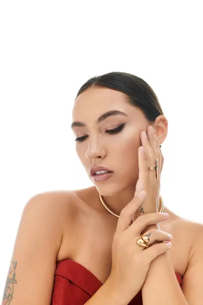A young woman with striking features gracefully displays her jewelry while posing thoughtfully. — Stock Photo