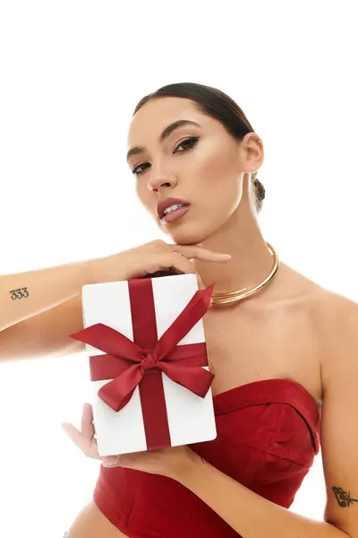 A stylish young woman showcases a chic gift, emphasizing beauty and grace in a bright setting. — Stock Photo
