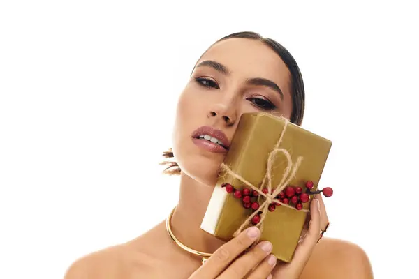 The stunning woman showcases a stylishly wrapped present adorned with festive decorations. — Stock Photo