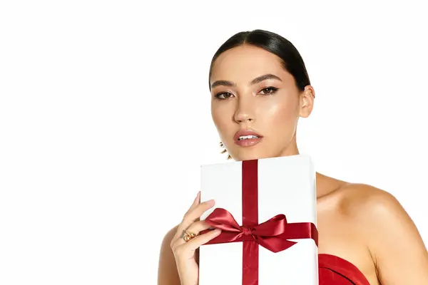 The young woman exudes elegance as she holds a gift, embodying joy and sophistication at the event. — Stock Photo