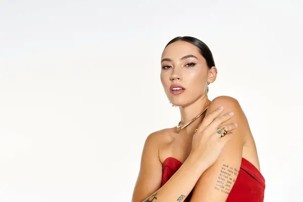A young woman confidently poses while showcasing her unique style and elegance in red. — Stock Photo