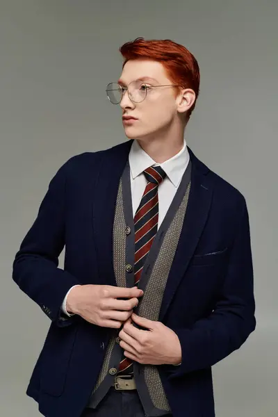 A young student with striking red hair showcases his layered winter outfit, exuding elegance and confidence. — Stock Photo