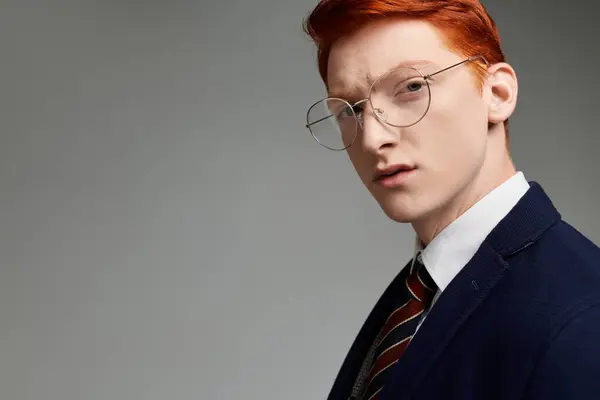 A young student with striking red hair models a fashionable layered winter outfit, complete with tie and blazer. — Stock Photo