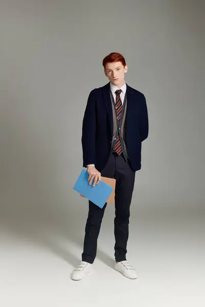 Um jovem com cabelo vermelho impressionante mostra sua roupa de inverno elegante enquanto está em um estúdio moderno. — Fotografia de Stock