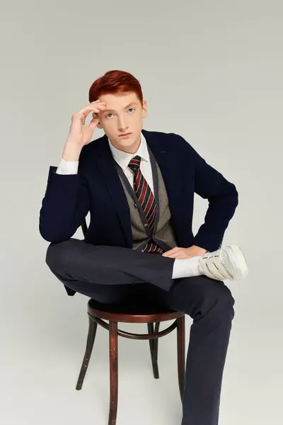 A young student dressed in an elegant winter outfit sits gracefully, exuding confidence and style. — Stock Photo