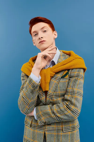 A young man with red hair poses confidently, flaunting an elegant winter outfit paired with a stylish blazer. — Stock Photo
