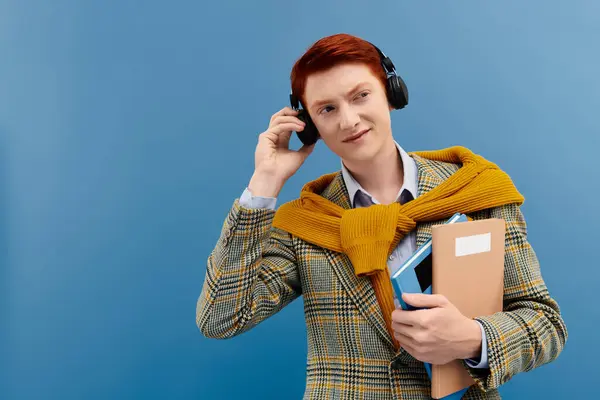 Un giovane uomo con i capelli rossi parla al telefono, vestito con un abito invernale chic in un ambiente da studio. — Foto stock