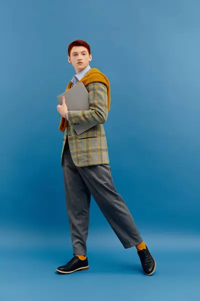 A handsome man in an elegant winter outfit poses confidently in a vibrant studio backdrop. — Stock Photo