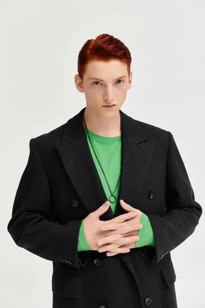 A young man showcases his fashionable winter coat while standing confidently in a contemporary studio. — Stock Photo