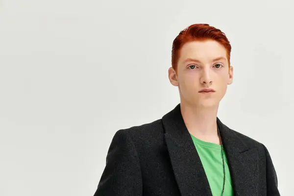 Un giovane uomo mette in mostra i suoi capelli rossi ed elegante cappotto invernale in un ambiente monolocale contemporaneo. — Foto stock