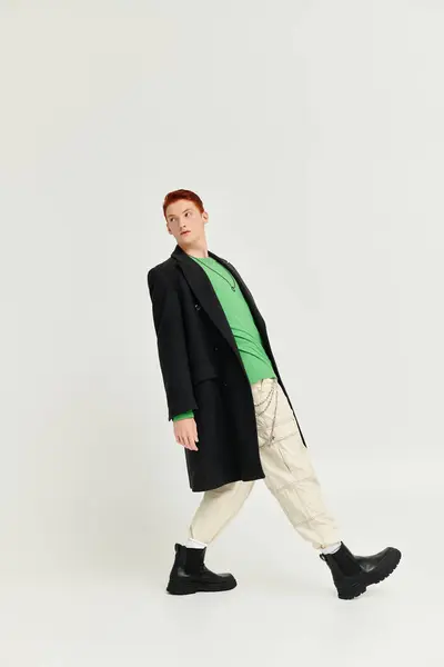 A stylish man in a sophisticated winter coat poses confidently in a neutral studio environment. — Stock Photo