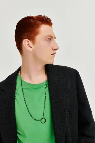 A fashionable man poses elegantly in a winter coat, exuding confidence in a vibrant studio environment. — Stock Photo