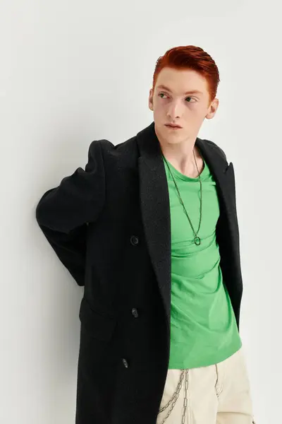 A confident young man with striking red hair showcases his fashion sense in a stylish winter coat. — Stock Photo