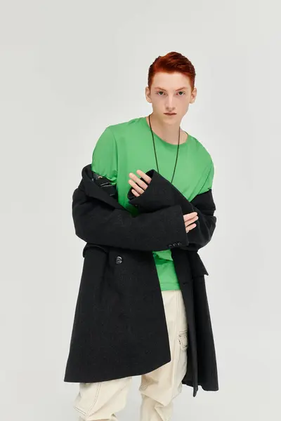 A young man with striking red hair models an elegant winter coat in a contemporary studio environment. — Stock Photo