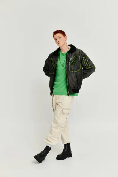 A stylish young man with red hair showcases fashion in a winter coat, embracing a contemporary studio vibe. — Stock Photo