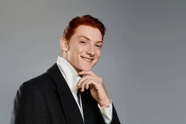 A young man with vibrant red hair showcases his fashion sense in a sleek winter coat, exuding charm and confidence. — Stock Photo