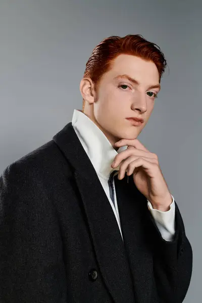 A young man with red hair showcases his fashionable winter coat while thoughtfully striking a pose. — Stock Photo