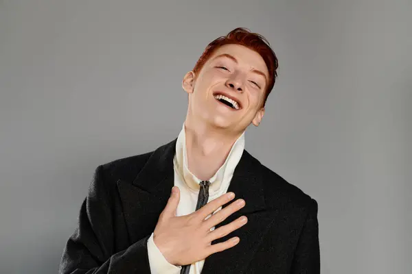 A cheerful young man with vibrant red hair showcases his charm in a fashionable winter coat while smiling. — Stock Photo