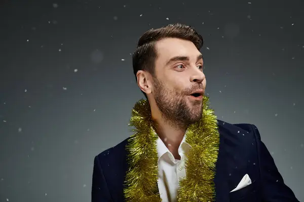 A young man expresses delight while celebrating with festive decorations in a winter atmosphere. — Stock Photo