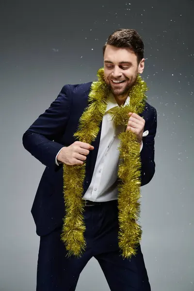 This handsome man in formal wear joyfully embraces a festive atmosphere with gold decorations — Stock Photo