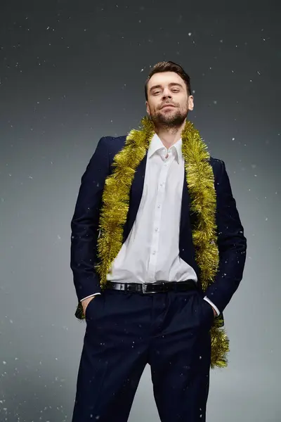 Dressed in a sharp suit, a young man poses elegantly with festive decorations around him. — Stock Photo