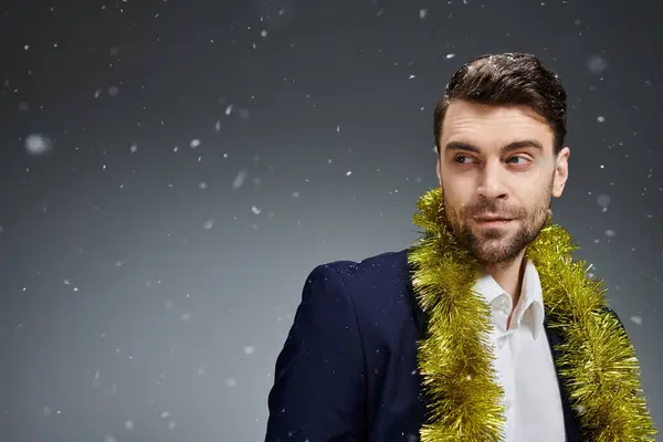 A stylish young man with a charming expression celebrates in a wintery atmosphere. — Stock Photo