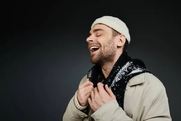 A cheerful young man wearing a winter coat and smiling joyfully in a cozy environment. — Stock Photo