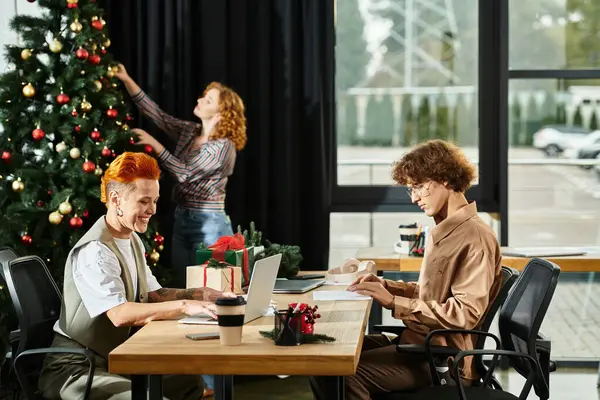 Colleagues gather to decorate the Christmas tree while enjoying each others company and gifts — Stock Photo